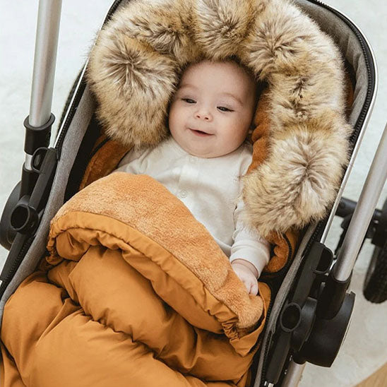 bébé souriant installé dans chancelière marron facile à installer