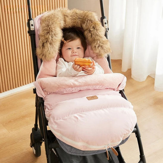 bébé installé dans chancelière rose imperméable
