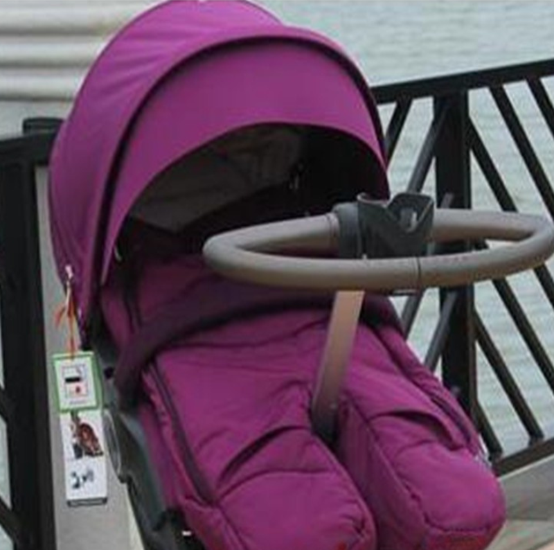 nid d'ange rose installé confortablement dans poussette
