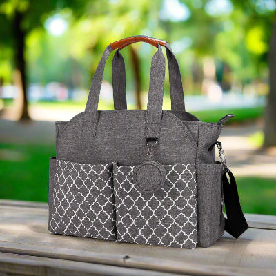 Sac à langer gris posé sur une table dans un parc