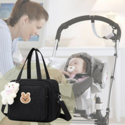 Un sac a langer noir et une maman souriante devant son bébé installé dans une poussette