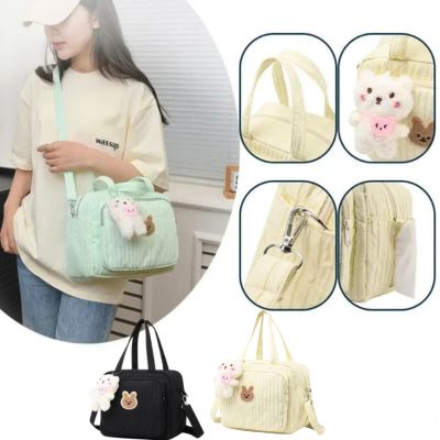 Sac a langer deux couleurs, avec détail de conception visible, porté sur l’épaule par une femme vue de face