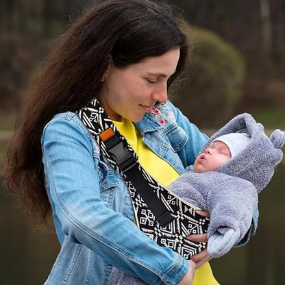 maman  avec bébé dans écharpe de portage bébé dans parc