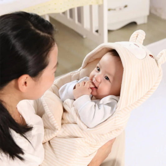 maman porte bébé dans nid d'ange cosy beige 