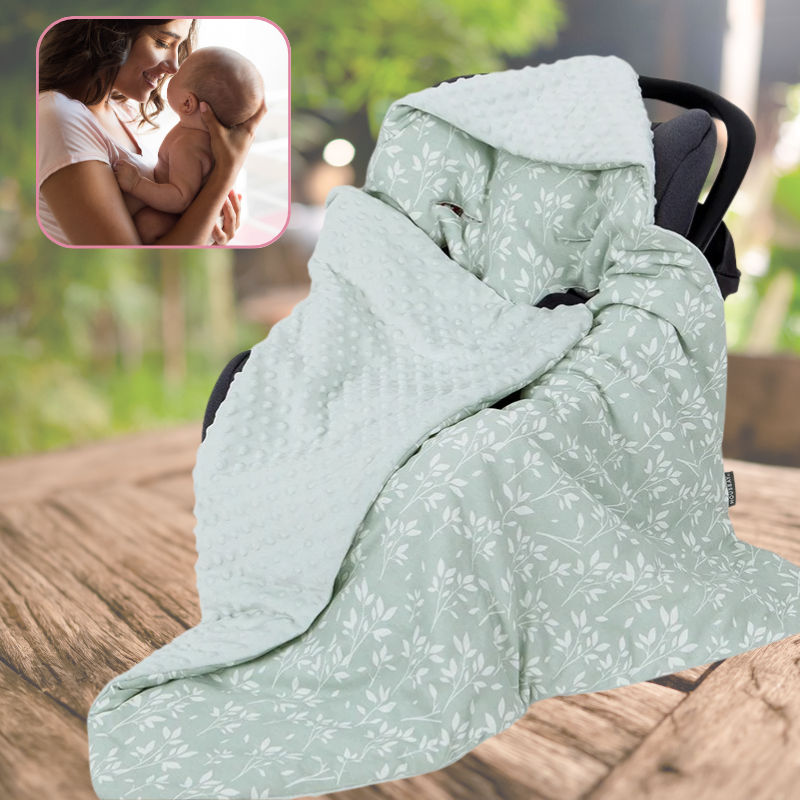 nid d'ange cosy vert plante posé sur une table ou un parc, maman tient bébé dans ses bras