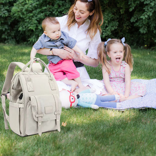 sac a langer bebe maman avec bébé heureux au parc
