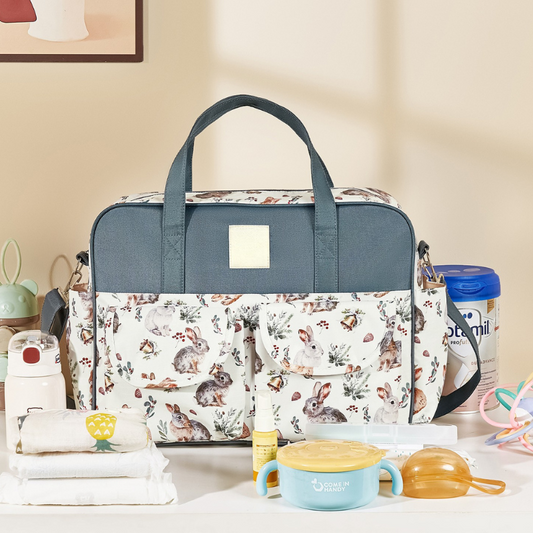 Sac a langer bebe avec tous les essentiels de bébé posés à côté sur une table